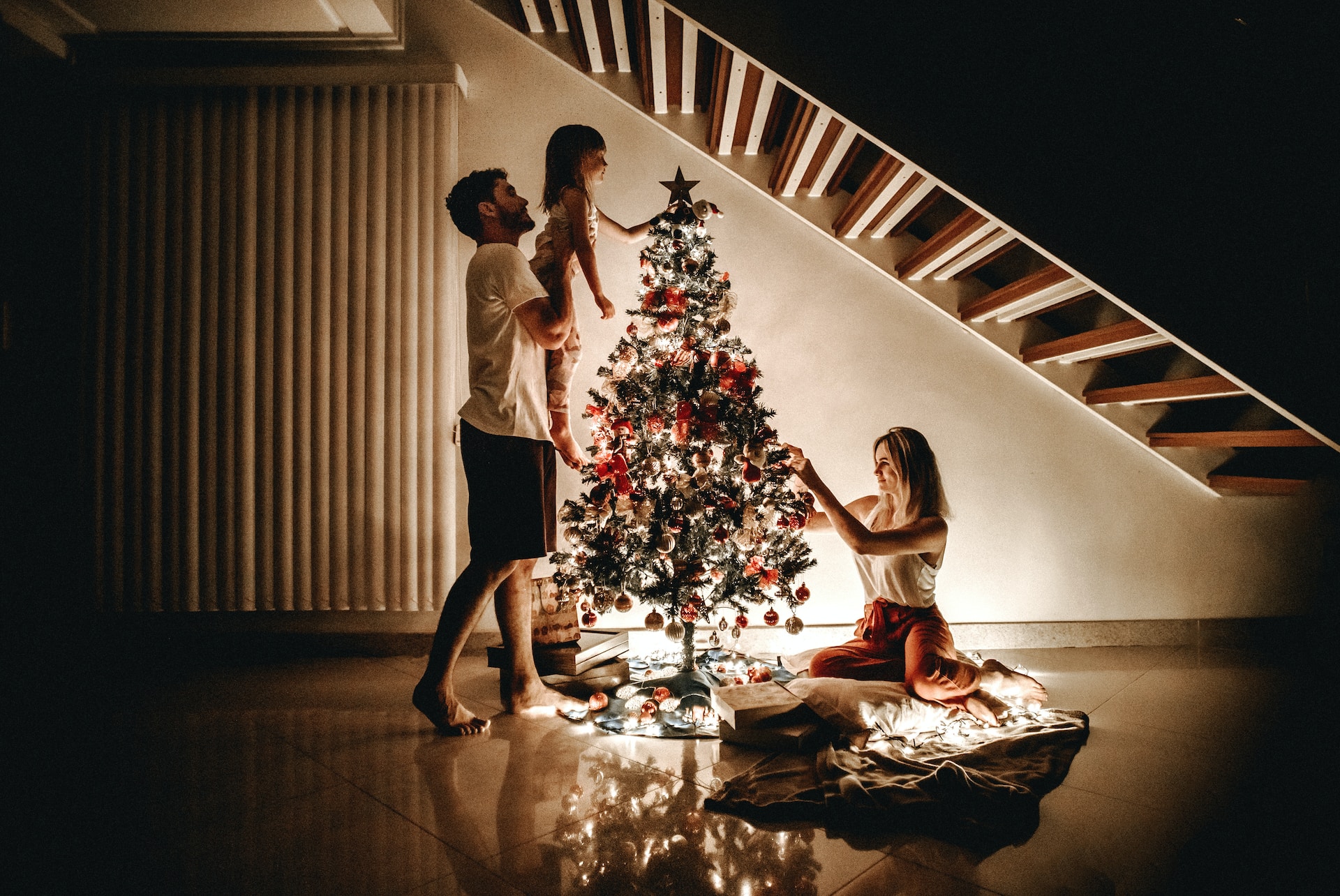 A family setting up the lights in a Christmas tree